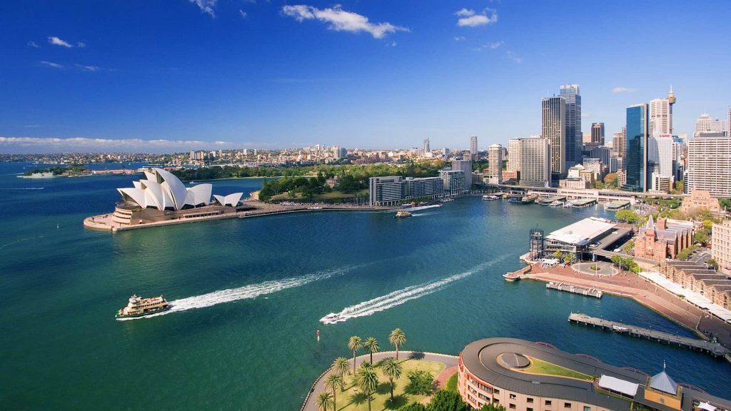 Vista aérea do país, com a Opera House de Sydney ao fundo. Intercâmbio de estudo e trabalho na Austrália