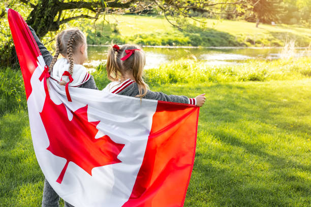 Duas meninas segurando uma bandeira do Canadá. Family day.