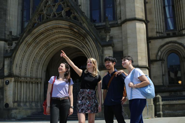 Turistas na frente de um prédio imponente em Manchester