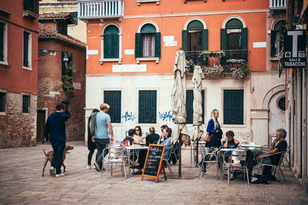 Fachada de restaurante na Itália com clientes sentados em mesas