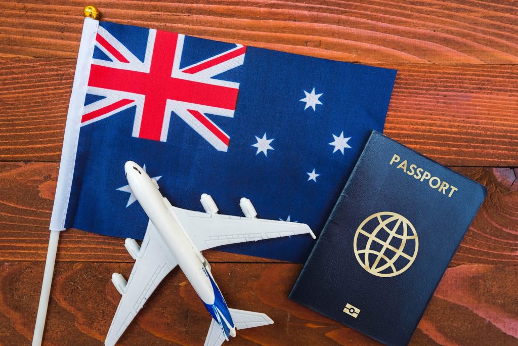 Passaporte e avião de brinquedo sobre a bandeira da Austrália | Comprovação financeira Austrália