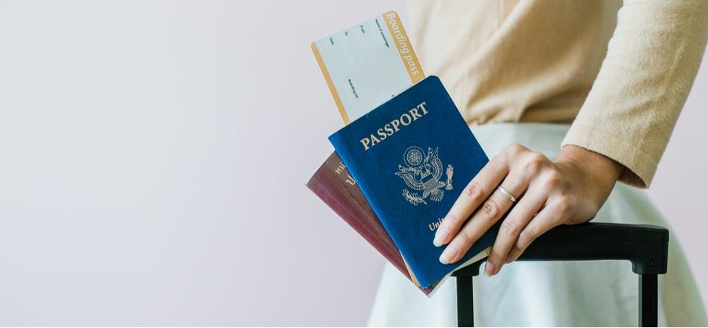 Turista segurando passaporte e mala para viajar
