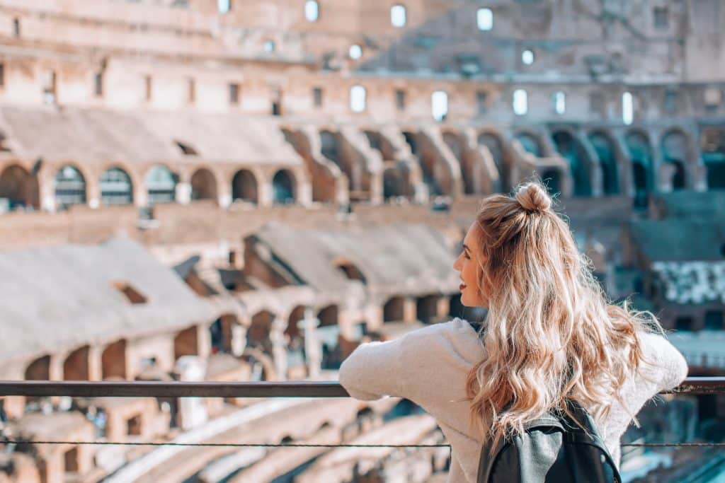 Mulher admirando o Coliseu ao fundo