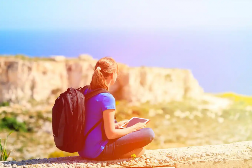 Turista sobre rochedo olhando para o horizonte de Malta